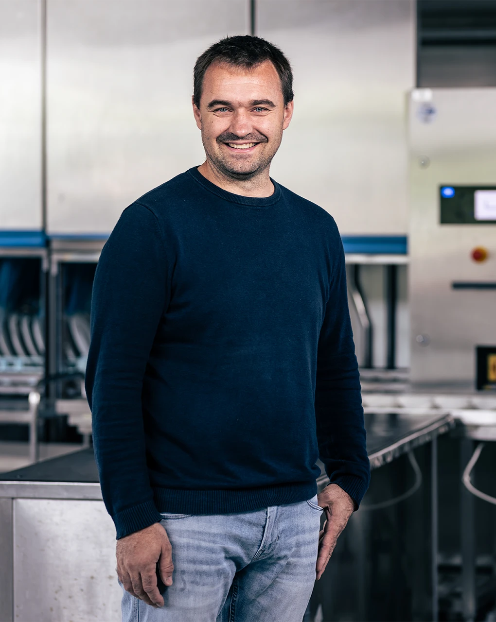 Ralf Borho, Geschäftsinhaber von Borho, vor einer Industriespuelmaschine 